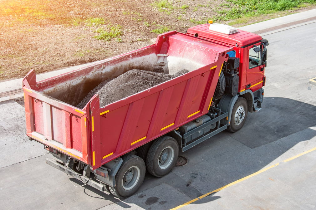 Truck with a body, asphalt during pavement repair.