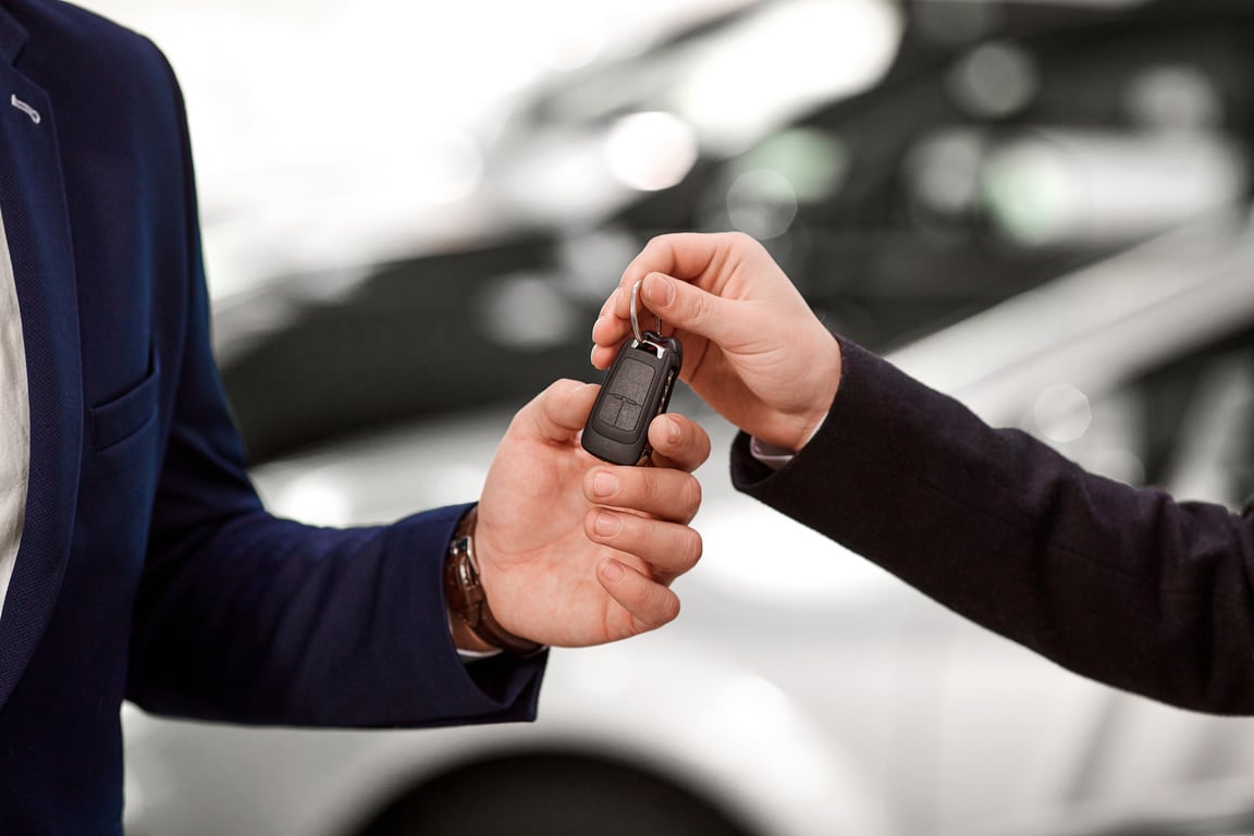 Car Salesman Handing Car Keys to Buyer