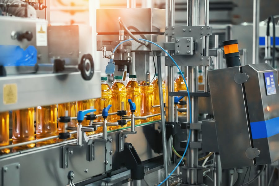 Juice in bottles on Conveyor belt, beverage factory interior, industrial production line